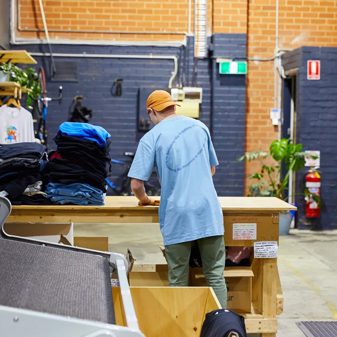 A person is folding custom hoodies at The Print Bar's Melbourne location