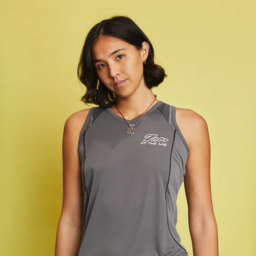 A person standing in front of a yellow background wearing a custom digitally printed sportswear tank top.