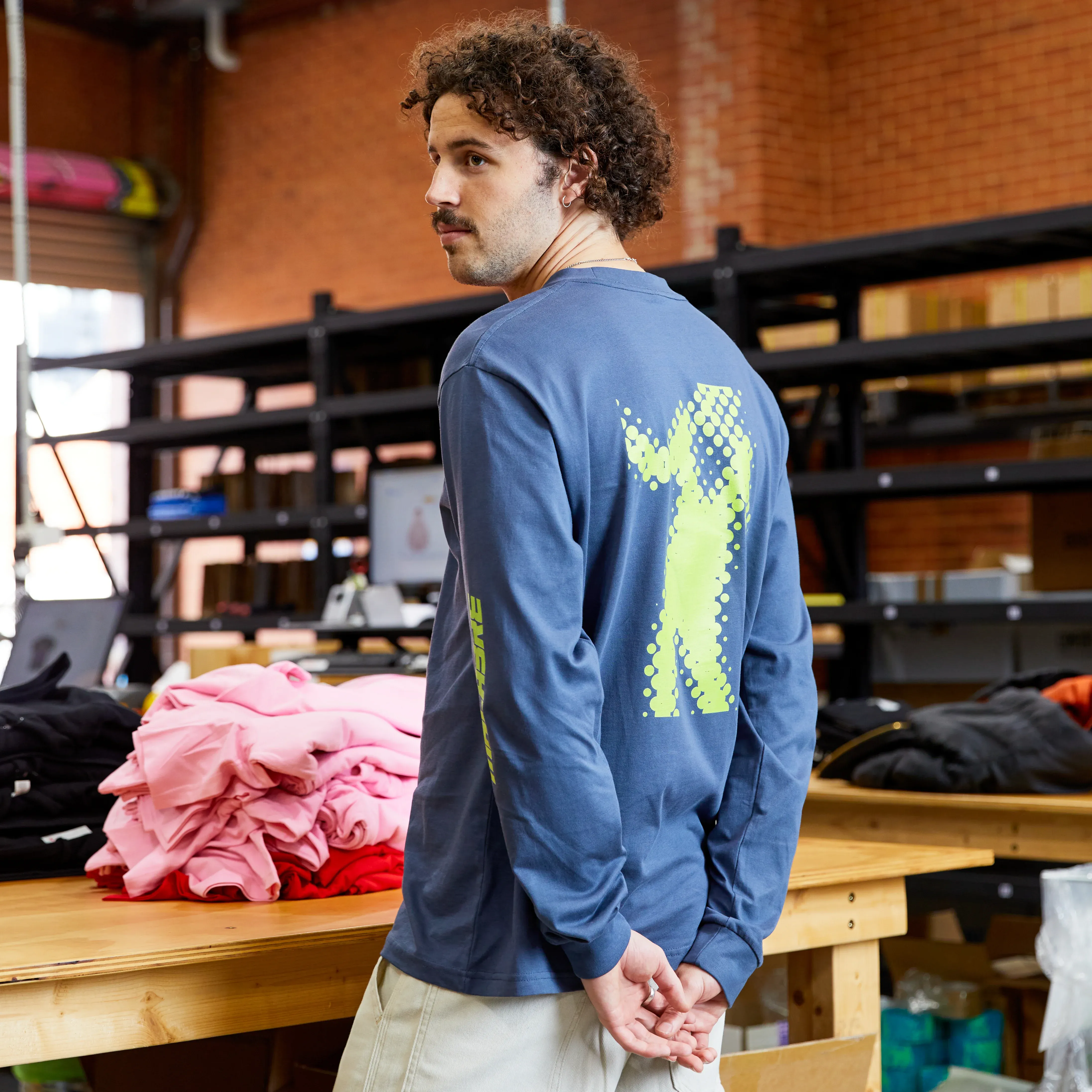 A person at The Print Bar Melbourne showing a custom digitally printed logo on a back of a long-sleeve t-shirt
