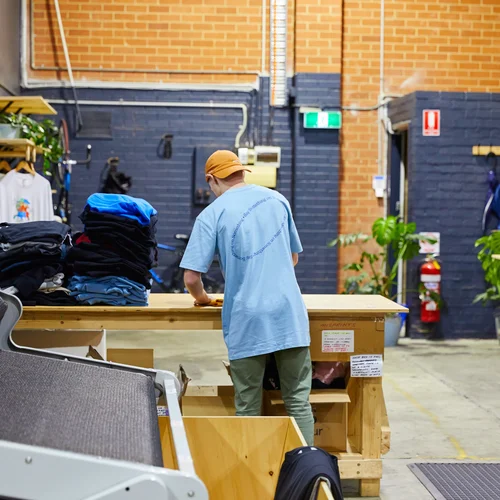 A person is folding custom hoodies at The Print Bar's Melbourne location