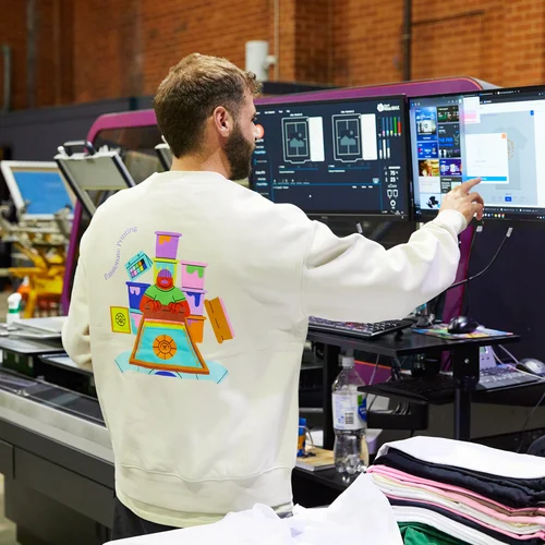 A person is printing a same day t-shirt order at The Print Bar's Melbourne location, it will be shipped to Sydney