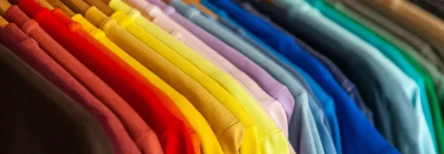 A row of shirts are hanging up on a clothing rack